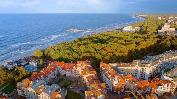 沐浴在Kołobrzeg码头阳光普照的宁静中，就像这张无人机拍摄的照片一样。广阔的木板路延伸到蔚蓝的波罗的海，而愉快的度假者漫步。图片下载