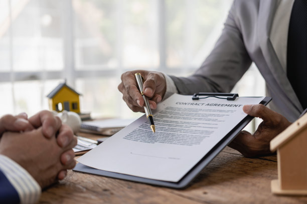 房地产经纪人讨论购房合同的条款，并要求客户签署合法签订合同的文件。卖房子。特写照片。图片下载