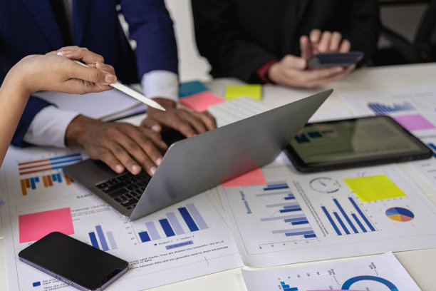 一群自信的年轻商人在讨论财务数据分析和商业战略项目的协作会议上使用电脑分析数据。图片下载