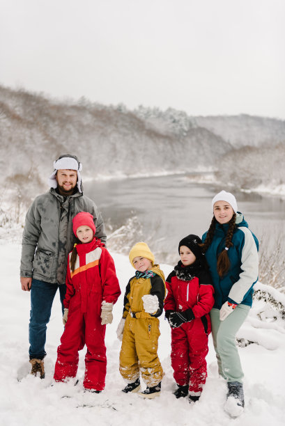 母亲，父亲，女儿，两个儿子在大自然的雪地里度过寒假。带着孩子的大家庭一起在雪林中享受山区的乐趣。照片上快乐、积极微笑的人。图片下载