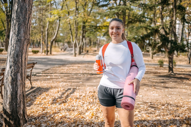 年轻女子手持运动垫上健身课的照片图片下载
