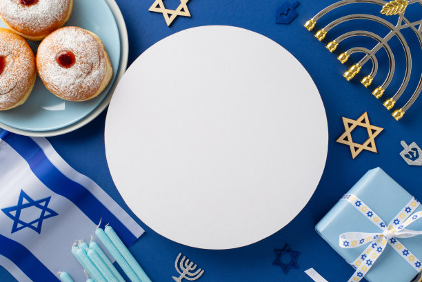 光明节庆祝餐桌装饰。经典的sufganiyot，盘子，大卫之星，以色列国旗，礼盒，烛台在深蓝色背景空圈文字或广告的头顶照片图片下载