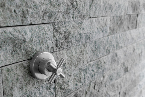 浴室石墙上的淋浴龙头图片下载