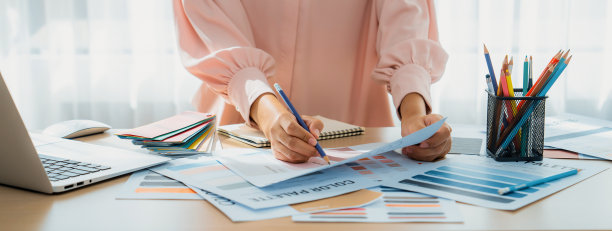 室内设计师比较笔记本电脑和文件的调色板。斑叶。图片下载