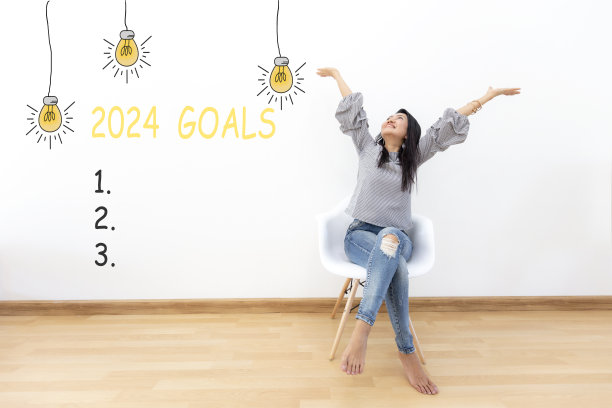 2024年的目标与年轻女子愉快和快乐的新年在椅子上。星星一起新年2024图片下载