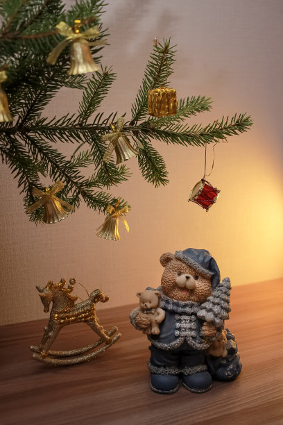 装饰雕像的古董金摇马和熊与圣诞树，在冷杉树下。喜庆的新年装饰，温馨的构图图片下载