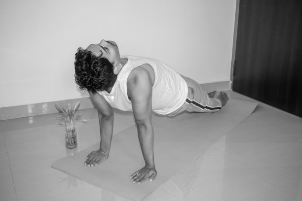 瑜伽修行者在健身房做骆驼瑜伽姿势。印度男子在练习瑜伽。瑜伽的概念。侧视图和黑白图片图片下载