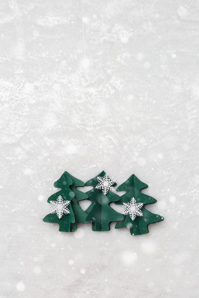 圣诞树剪纸，寒假背景，雪花飘飘。手工制作的绿色冷杉装饰雪花在白色的皮毛。唯美的顶视图，极简的平面布局趋势格局，节日心情愉快图片下载