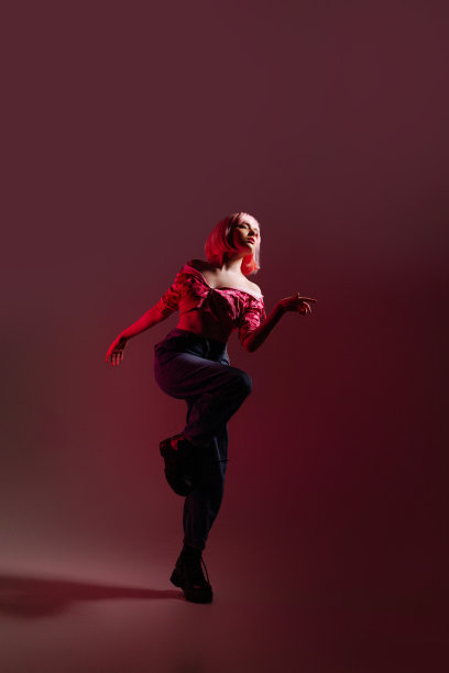 一名女模特站在粉红色的背景上拍摄照片。图片下载