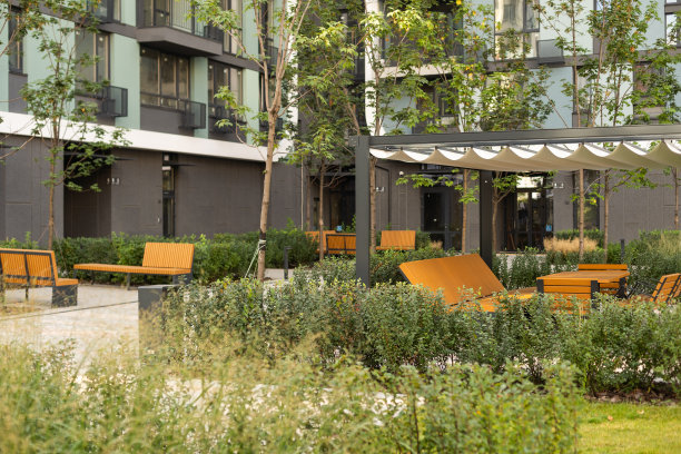 天井。花园。都市、中性、户外的生活空间。外观照片。户外客厅有沙发，舒适的靠垫，抱枕，椅子和茶几。后院有绿色植物。图片下载