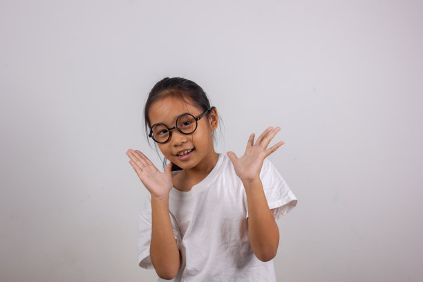 照片中可爱可爱的小女孩开心地举起拳头微笑图片下载