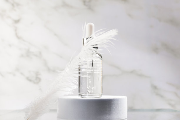 面部精华与柔软细腻的羽毛在大理石背景图片下载