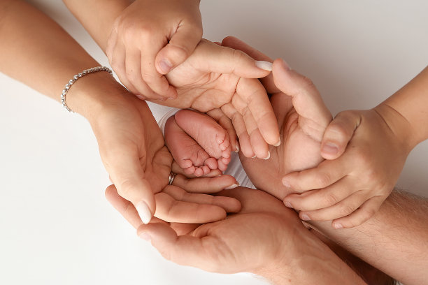 孩子的脚在妈妈手里，在爸爸手里，在父母手里。一个小新生儿的脚特写。小婴儿的腿。妈妈和她的孩子。幸福家庭概念。美丽的概念形象的母性股票照片。图片下载