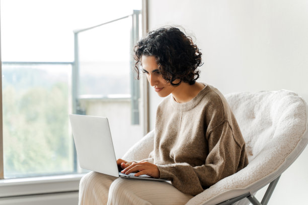 卷发女人看镜头打字笔记本电脑人像照片图片下载