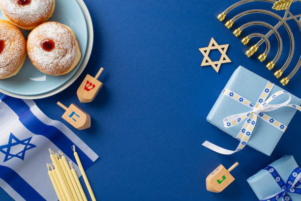 向光明节致敬，顶视图照片设有sufganiyoot，大卫之星，以色列国旗，礼盒，烛台烛台，dreidel设置在蓝色背景，理想的文本或广告整合图片下载