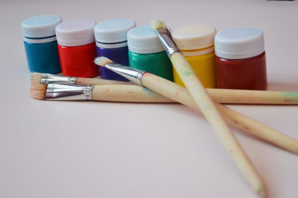 罐子里装着明亮的水粉颜料和不同大小的艺术刷。爱好、绘画、创意素材。图片下载