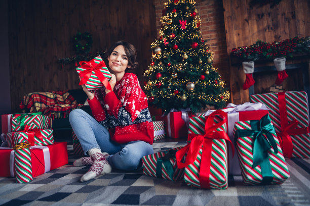 全身照片横幅传统女孩每一个新年快乐打开意外的惊喜，在壁炉背景孤立的圣诞树附近图片下载