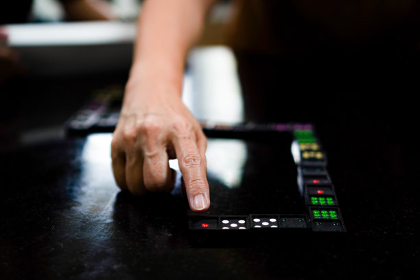 家庭成员在家里一起玩多米诺骨牌游戏的照片。图片下载