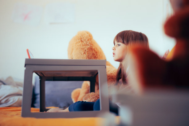 躺在床上看动画片的小女孩感到恶心图片下载