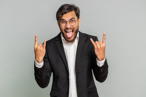 快乐的商人摆出摇滚的姿态，酷炫的手势，疯狂的表情跳舞，胜利，胜利图片下载