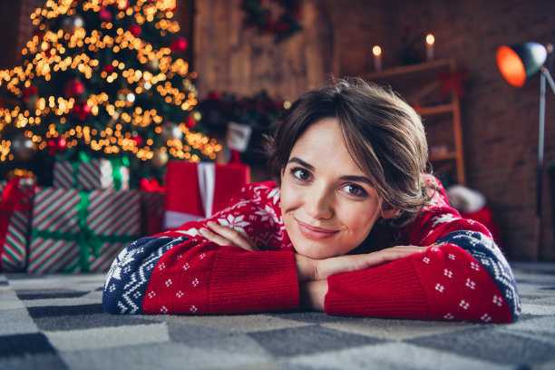 躺在地毯上的特写照片圣诞氛围工作室室内年轻有趣可爱的女孩舒适的气氛双手合十等待圣诞老人在家里图片下载