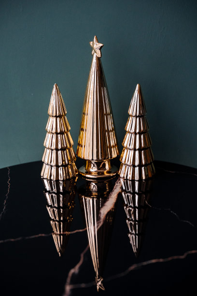 极简主义的三棵装饰的金色小圣诞树的照片。圣诞树的装饰品。新年和圣诞节的气氛。图片下载