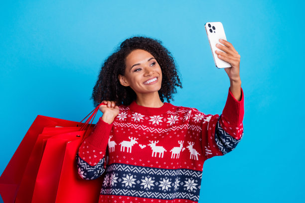 照片快乐有趣迷人的女孩穿着时尚丑陋的毛衣记录视频步行商店降临圣诞节孤立的蓝色背景图片下载