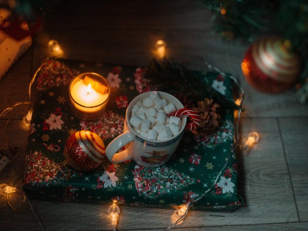 新年拐杖糖与可可和棉花糖一起放在杯子里，背景是舒适的圣诞圣诞树礼物和圣诞球。糖果和圣诞礼物。除夕夜图片下载