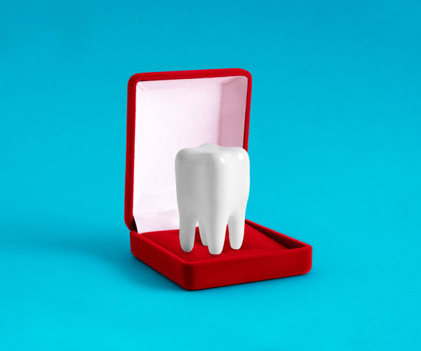 白色健康牙齿在蓝色背景的红色天鹅绒首饰盒。极简艺术牙科诊所广告海报。图片下载