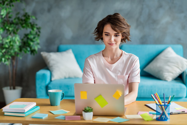 照片的年轻女子波波头使用她的苹果笔记本电脑隐藏的标志品牌椅子项目经理孤立的工作场所的办公室背景图片下载