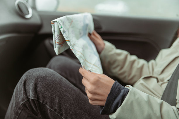 这个女孩正坐在车里，看着一张山的地图图片下载