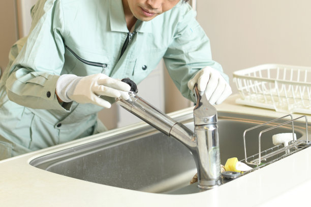 亚洲男工人在家检查厨房水龙头图片下载