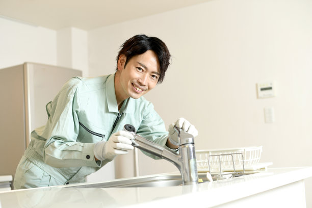 亚洲男工人在家检查厨房水龙头图片下载