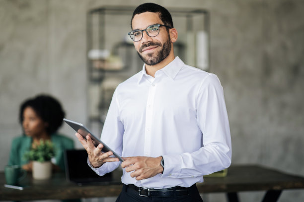 年轻的中东商人在办公室里拿着平板电脑的肖像图片下载