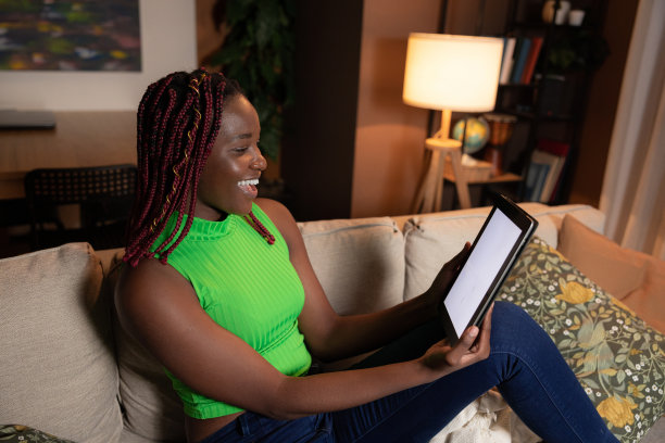 笑容满面，牙齿洁白，忙碌的妈妈用她的平板电脑管理日程安排，与家庭成员沟通，完成家务图片下载