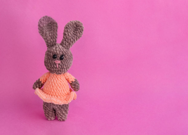 针织玩具兔在一个粉红色的背景与复制空间。象征着新的一年图片下载