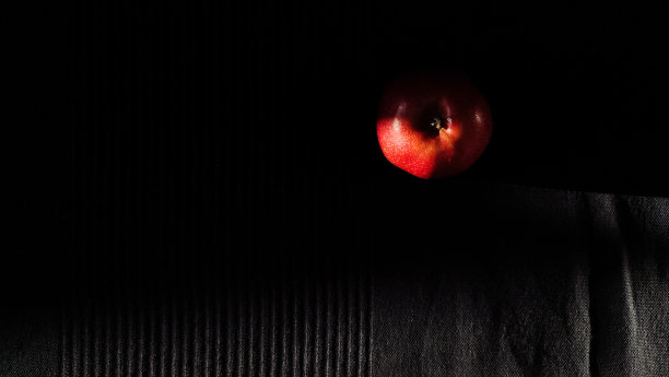 红苹果，黑色织物背景。图片下载