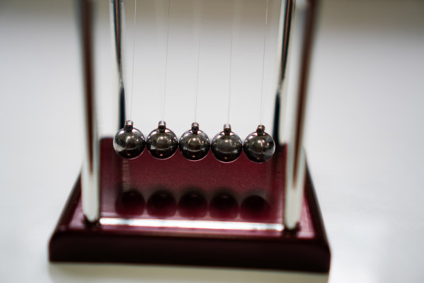 牛顿摇篮平衡球的特写照片，练习冥想时，在桌子上工作。图片下载