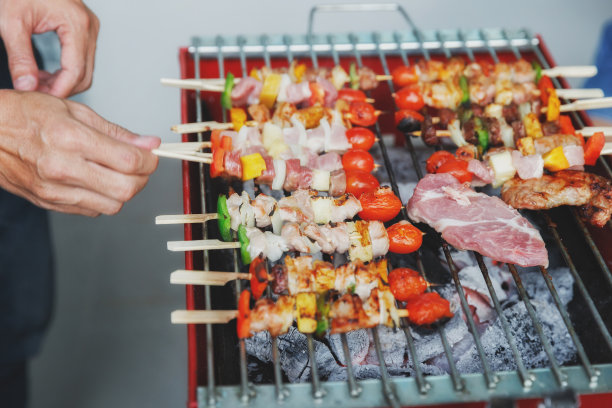 一个男人在宴会上烤猪肉和烤肉。食物，人和家庭时间的概念。图片下载
