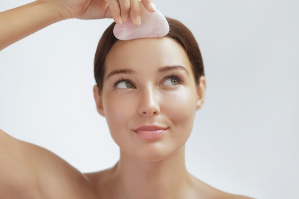 女性青春和护肤照片与自我面部按摩瓜沙工具图片下载