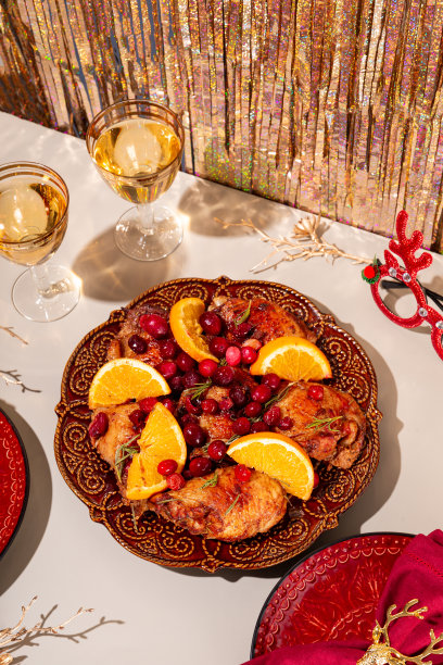 圣诞烤鸡配蔓越莓和橙子和两杯香槟在一个节日的现代餐桌垂直照片图片下载