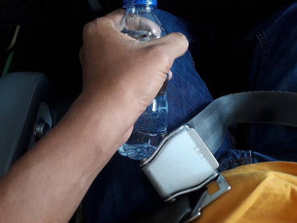 手提矿泉水瓶在飞机机舱的桌子上图片下载