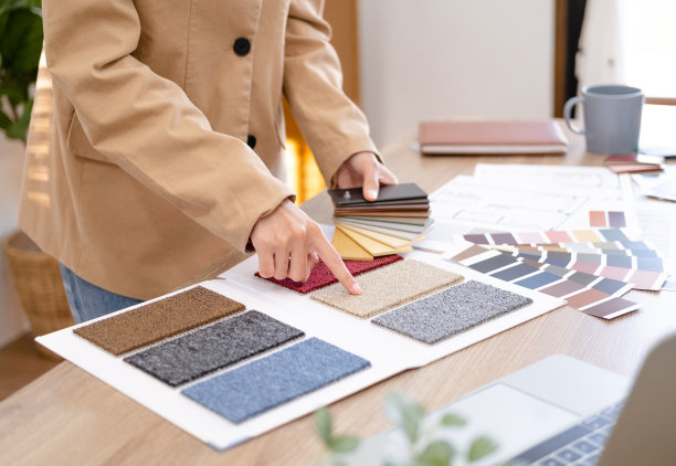 年轻的亚洲女性室内设计师或建筑师，在办公室用图纸，材料样品和笔记本电脑进行创意项目。经营房地产，家装装修理念。图片下载