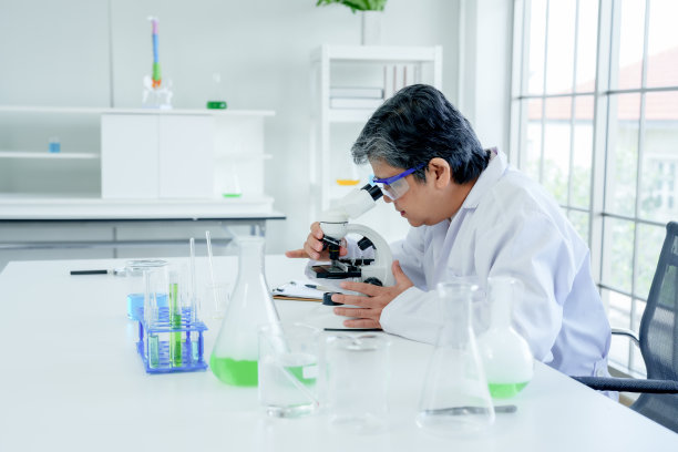 手持老年女教师、理科教师，穿着粘胶实验服，手持实验烧瓶、摇玻璃瓶测试一些物质，在教学前在实验室准备教材。图片下载