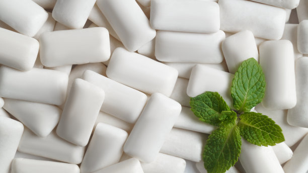 美味的口香糖和新鲜的薄荷叶为背景，俯视图图片下载