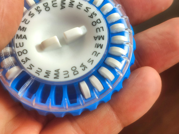一个蓝色的圆形每日药丸分配器用于激素替代疗法，用西班牙语命名图片下载