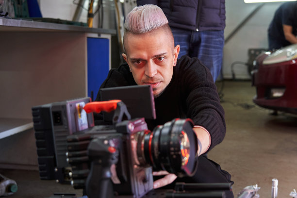 摄像师用镜头看着专业电影摄影机的屏幕。设置拍摄和取景设置图片下载