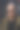 一名白头发、戴着墨镜的白人青年穿着毛衣和绿色夹克，站在阳光明媚的地方，表情严肃图片下载