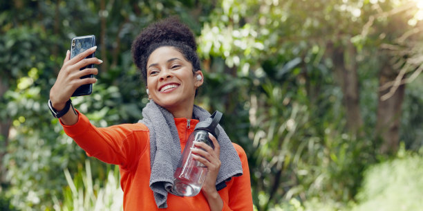 自拍，自然女人和微笑健身，户外运动和上传记忆照片到社交媒体应用程序。摄影，森林模型和头像公园运动员，跑步者和快乐锻炼图片下载