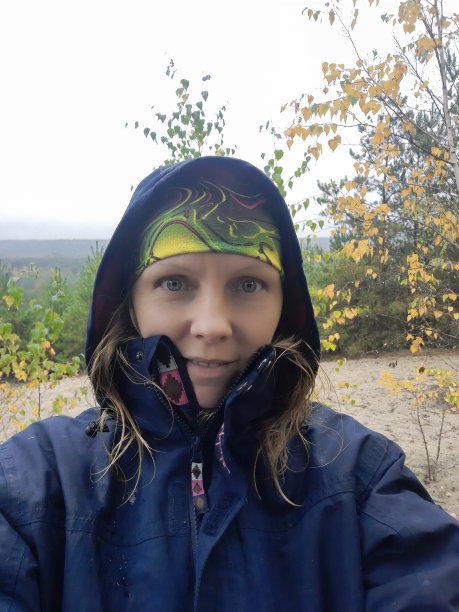 年轻女游客微笑着在城外下雨天自拍。图片下载